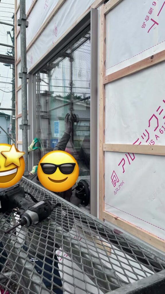 新事務所のガラスの位置を微調整する職人さん